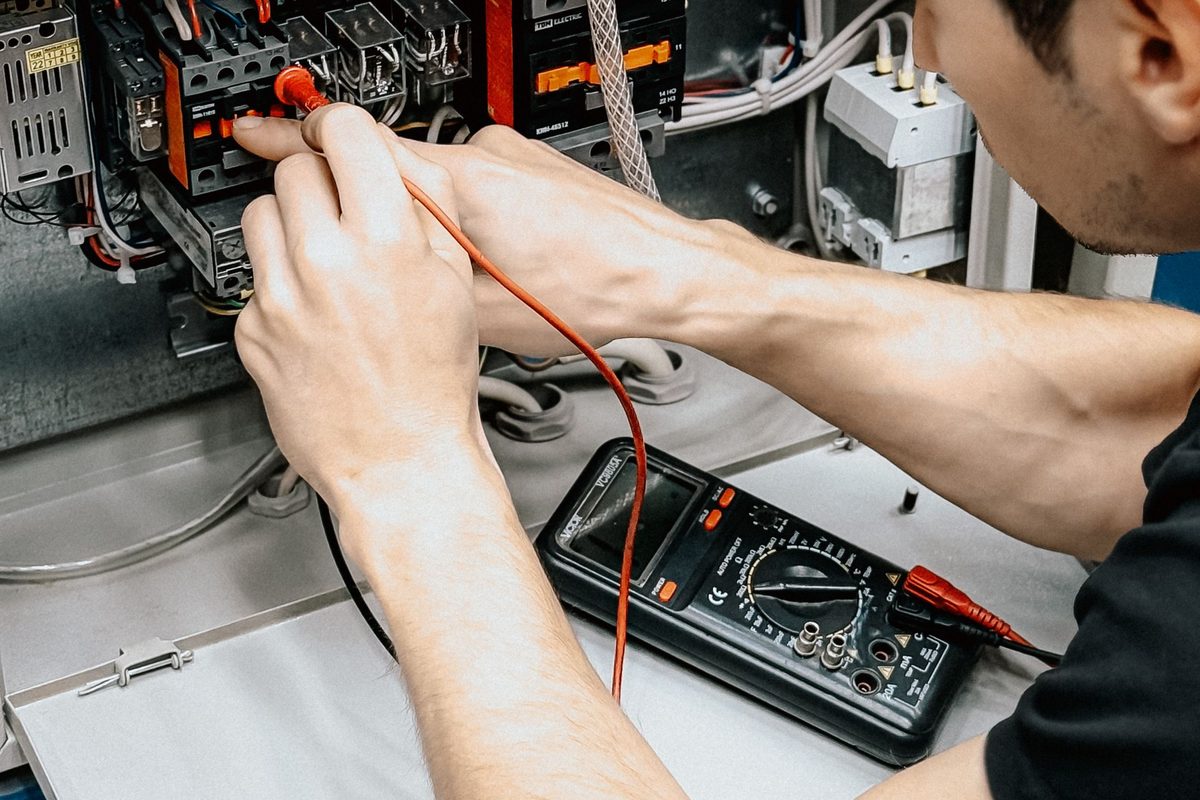 Elektriker misst mit dem Multimeter an einer Unterverteilung